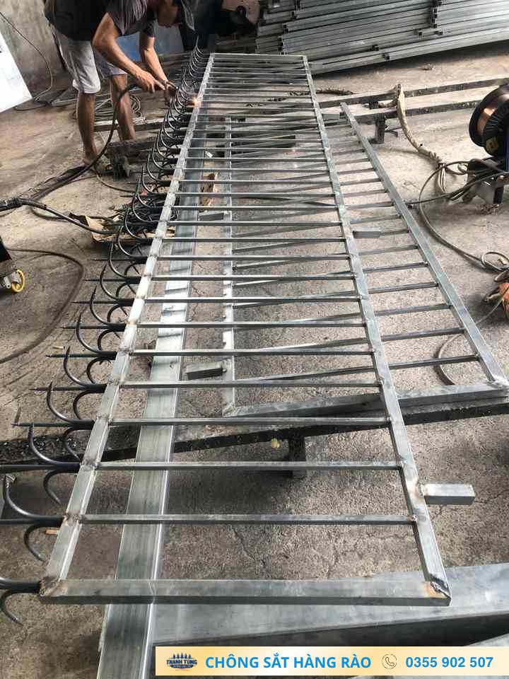 Thợ thực hiện gia công chông hàng rào 3 chia trên khung sắt