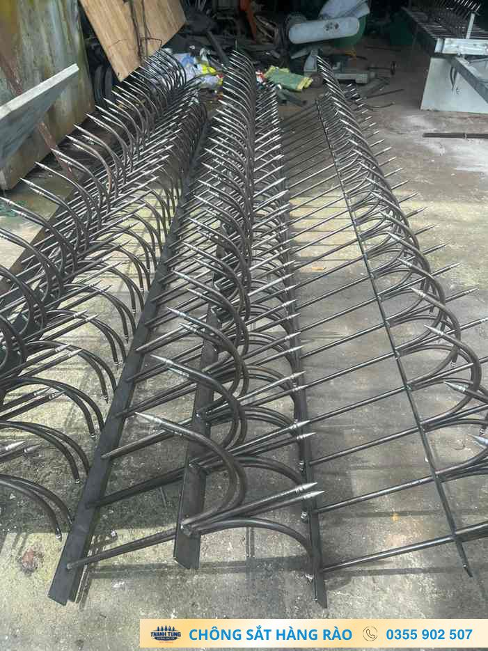 Nhiều dãy chông hàng rào uốn cong được xếp trên khung sắt trong xưởng