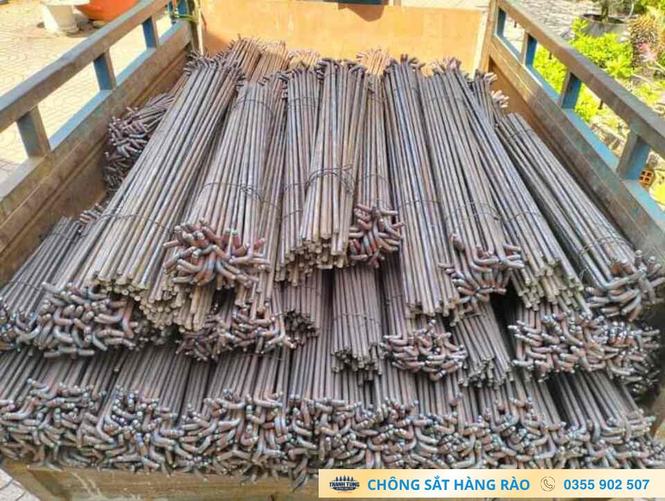 Nhiều bó thanh kim loại dài có phần đầu uốn cong được xếp trên sàn