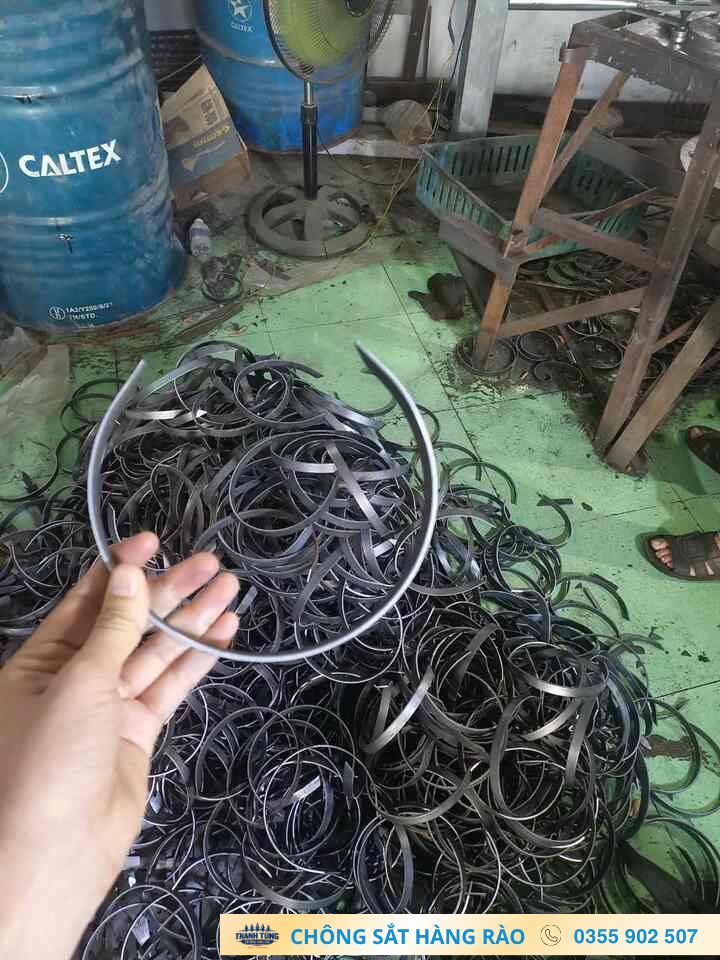 Một vòng kim loại được cầm phía trên nhiều vòng cùng dạng trong xưởng
